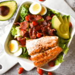 Large salad with bacon, egg, avocado, tomato and honey mustard