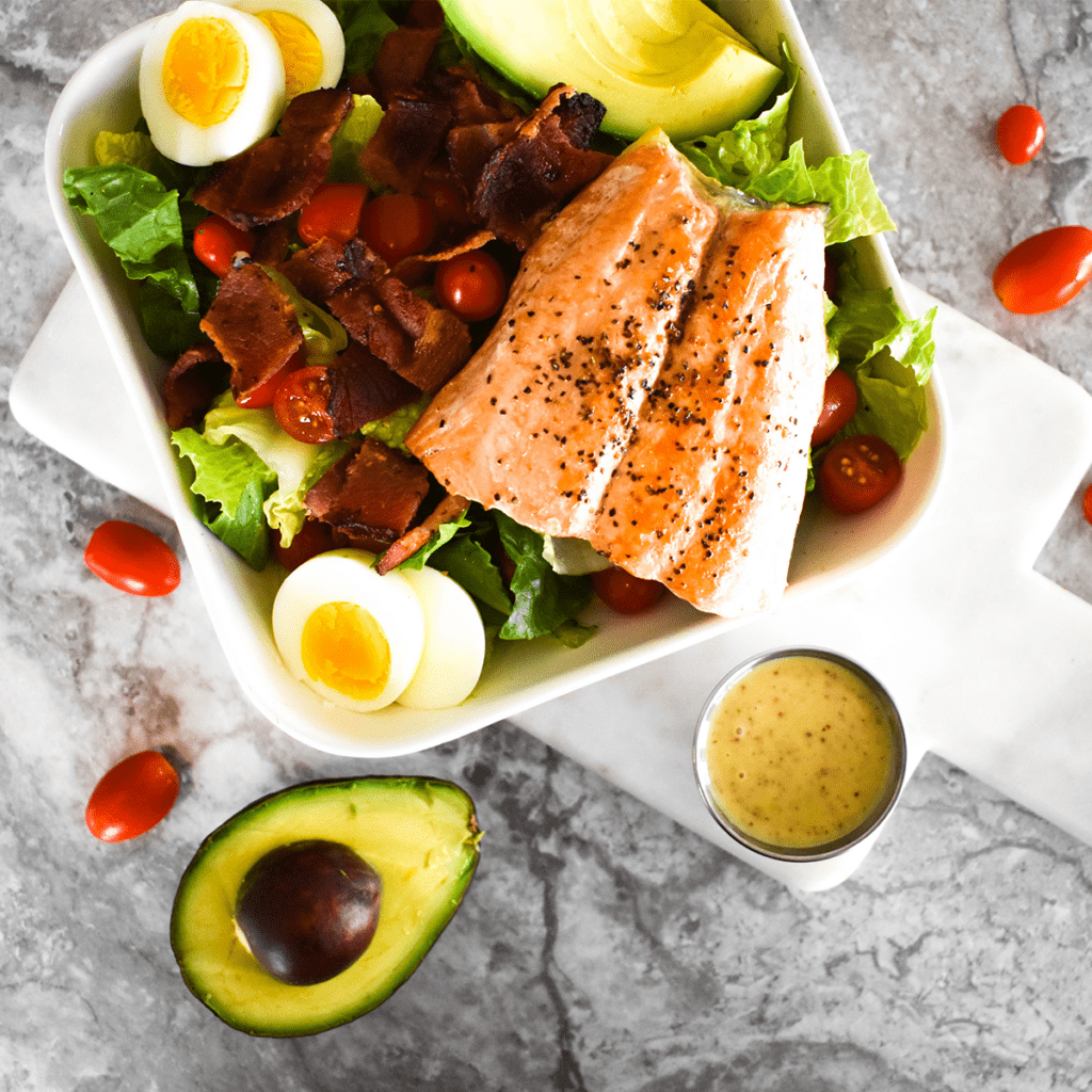 Large salad with bacon, tomato,egg, avocado and honey mustard