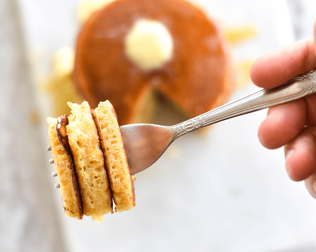 Fluffy pancakes stacked on a fork.