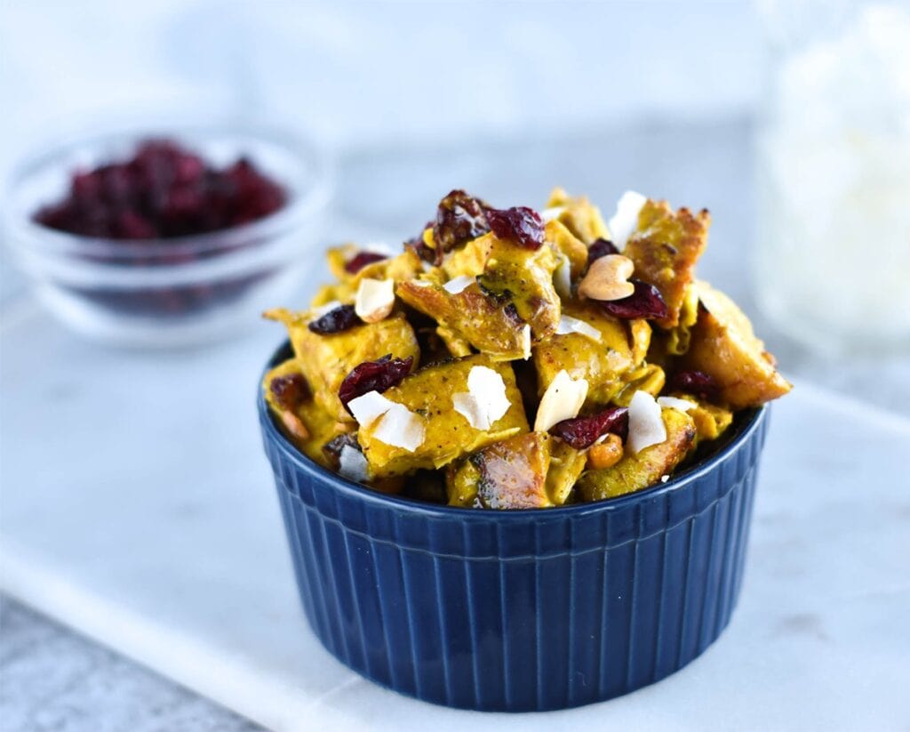 Bowl of chicken salad with curry, cranberries, coconut and cashews