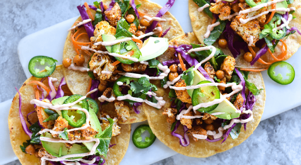 Close up of tacos with avocado, kale, cabbage, chickpeas and cauliflower