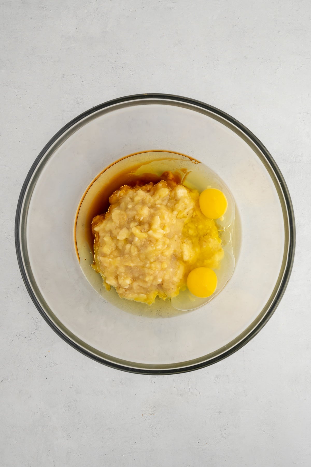 Mixing together wet ingredients for sugar-free gluten-free banana muffins.