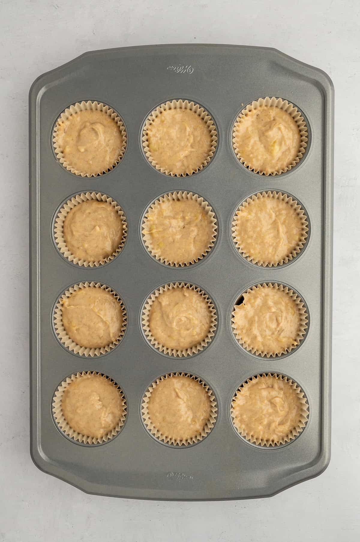 Muffin batter in lined muffin tin.