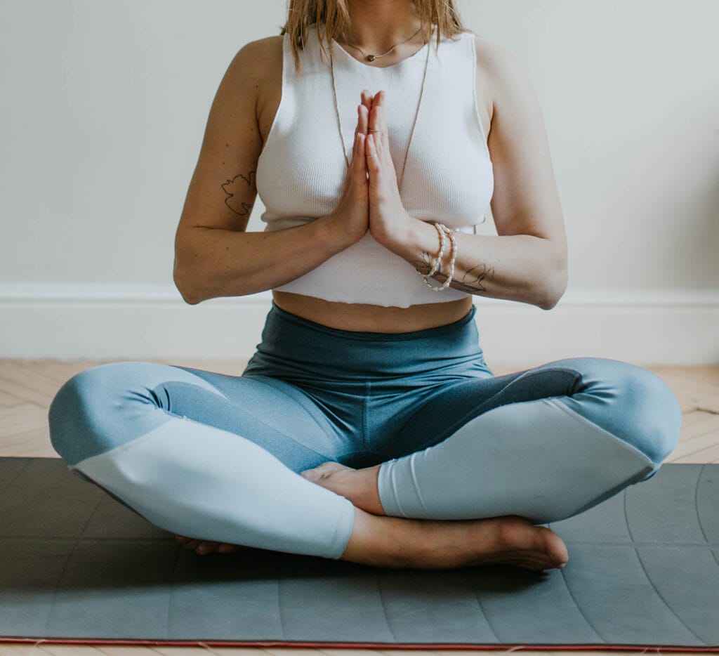 Lady meditating with legs crossed on the floor