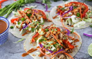 Colorful Thai Tacos with purple cabbage, ground chciken, red bell peppers and cilantro.