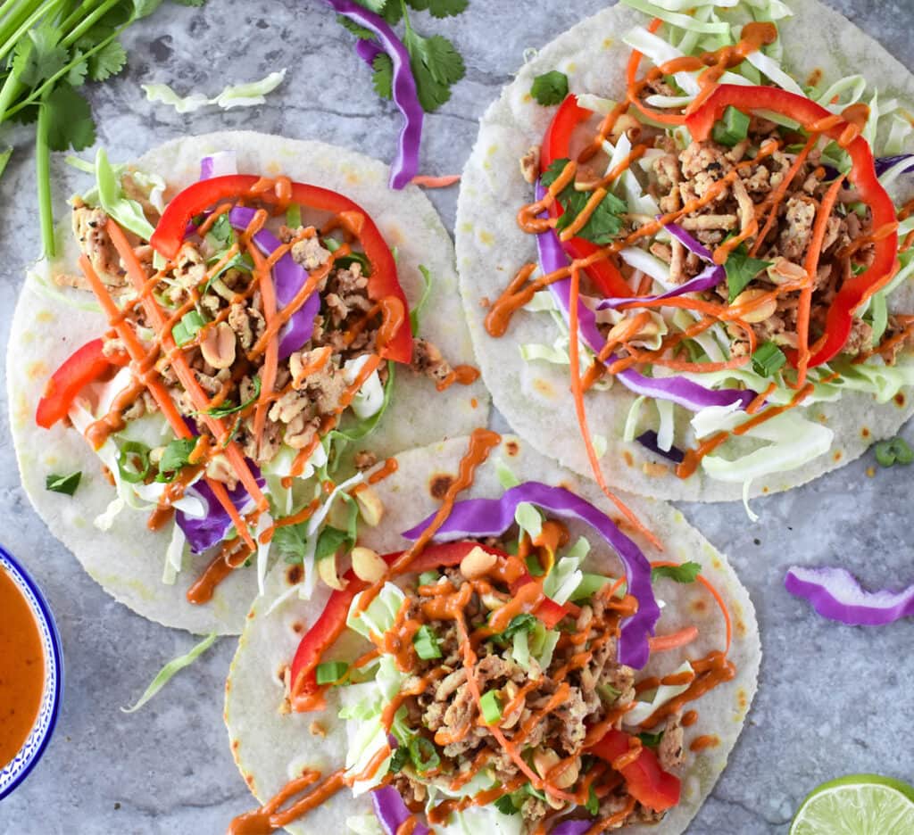 Colorful Thai Tacos with purple cabbage, ground chciken, red bell peppers and cilantro.