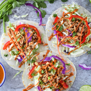 Colorful Thai Tacos with purple cabbage, ground chciken, red bell peppers and cilantro.