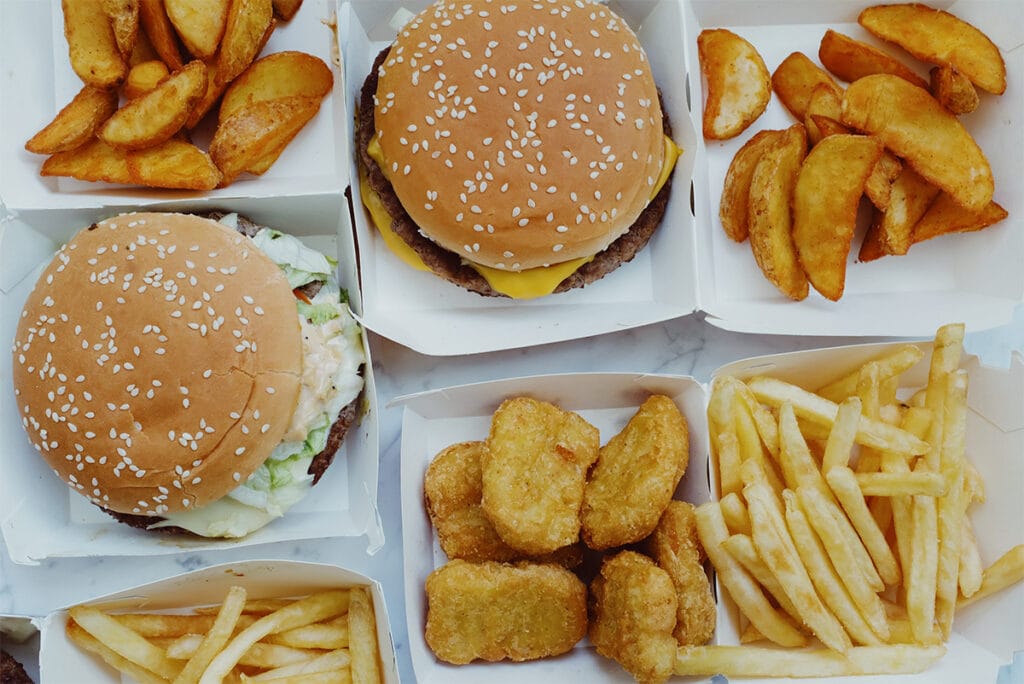 Fast food spread with chicken nuggets, burgers and fries.