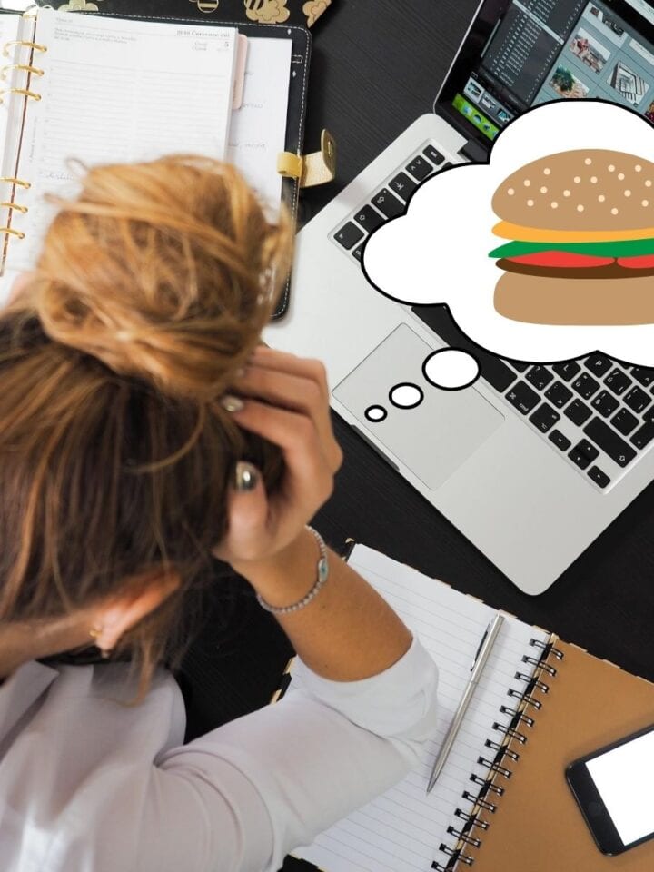 Girl looking stressed out over her computer. She has a thought bubble with a cheeseburger in it.