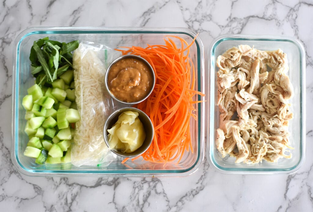 Meal prepped chicken in a container with rice and veggies.