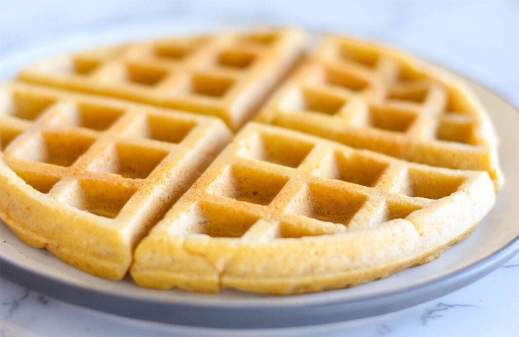 Golden, crispy paleo waffles on a plate.