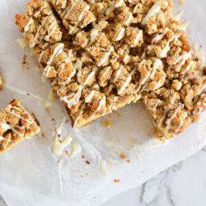 Keto cinnamon coffee cake with drizzled icing on parchment paper.