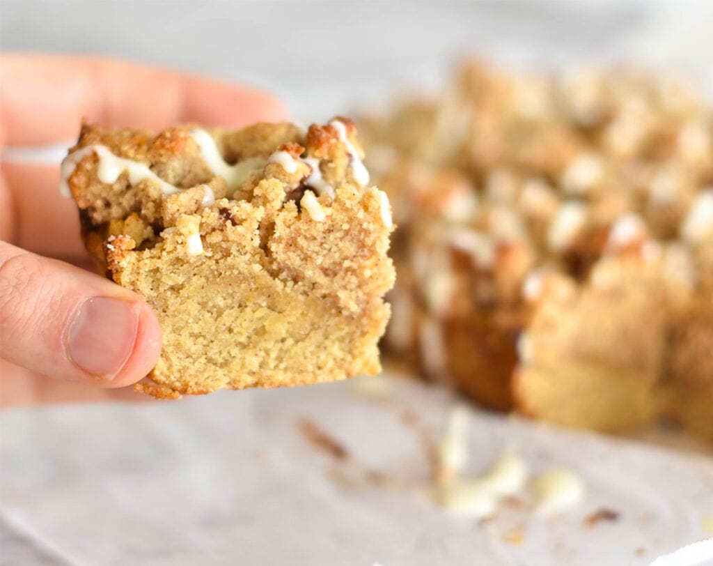 Slice of cinnamon coffee cake in hand.