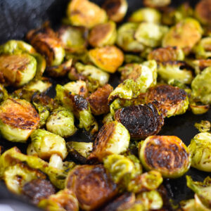 Cast iron skillet filled with caramelized brussel sprouts.