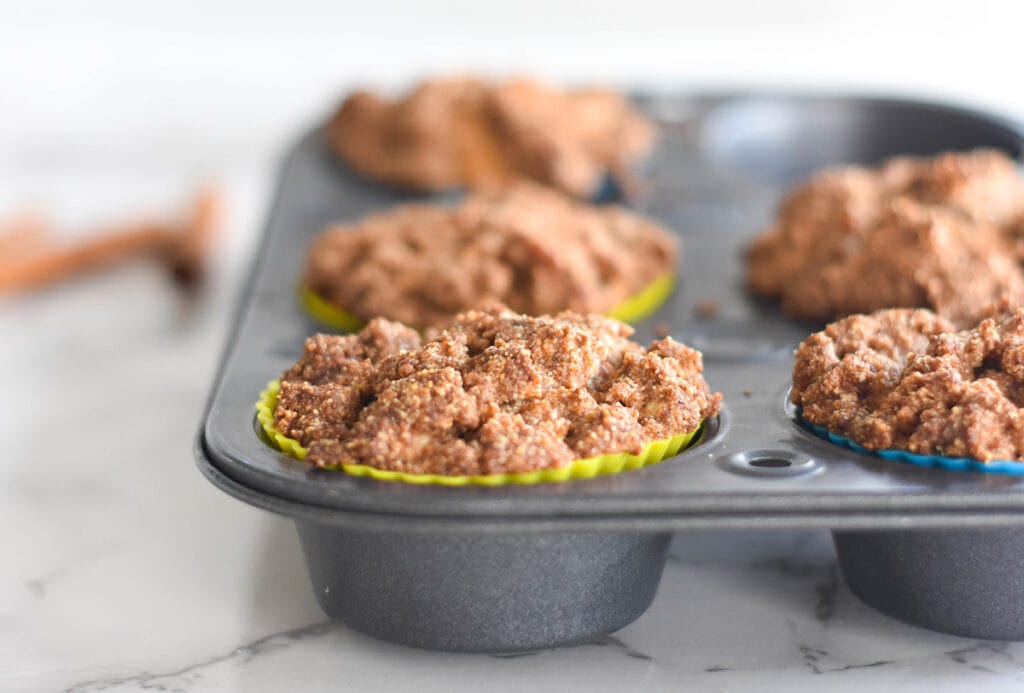 Close up on muffins with crumb topping in a muffin tin.