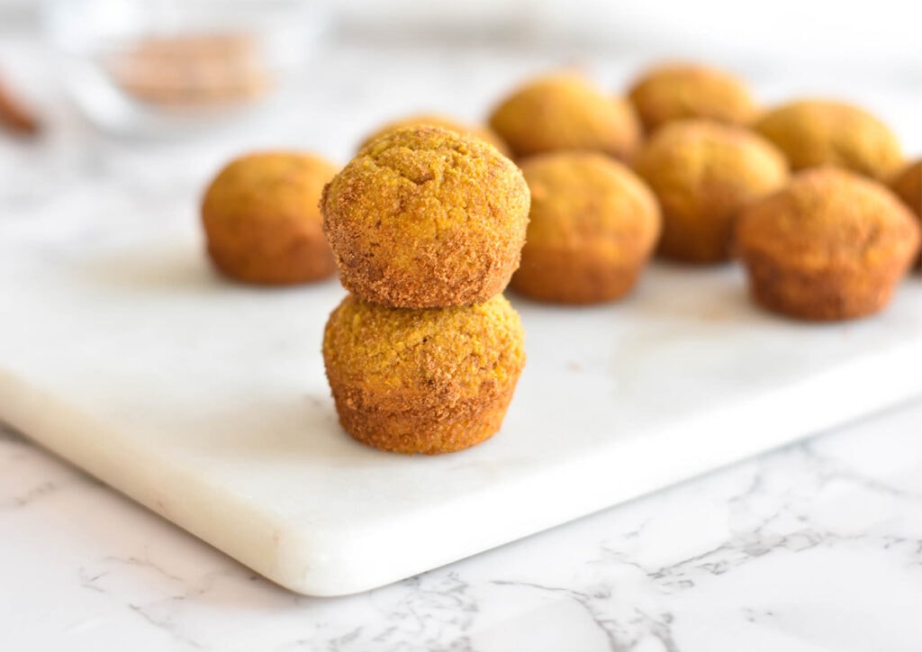 Two stacked donut holes covered in cinnamon coconut sugar.