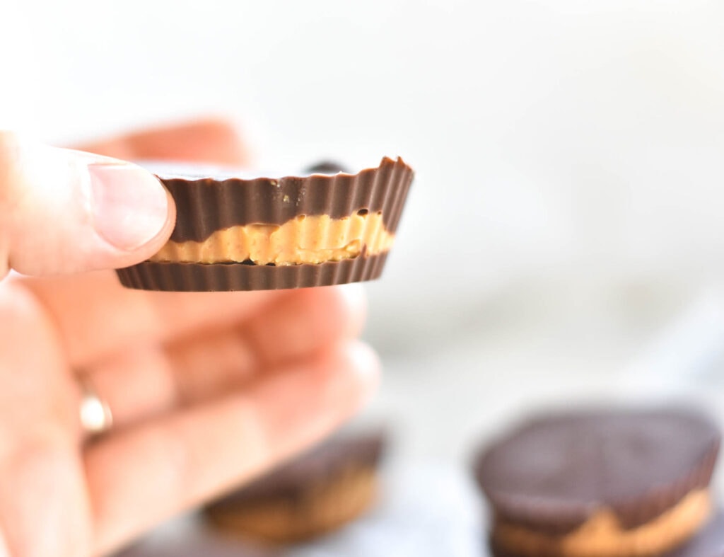 Hand holding a low carb chocolate and peanut butter cup.