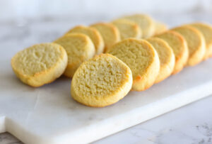 Tray of layered golden yellow shortbread cookies.