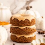 Stack of baked paleo pumpkin donuts with icing.