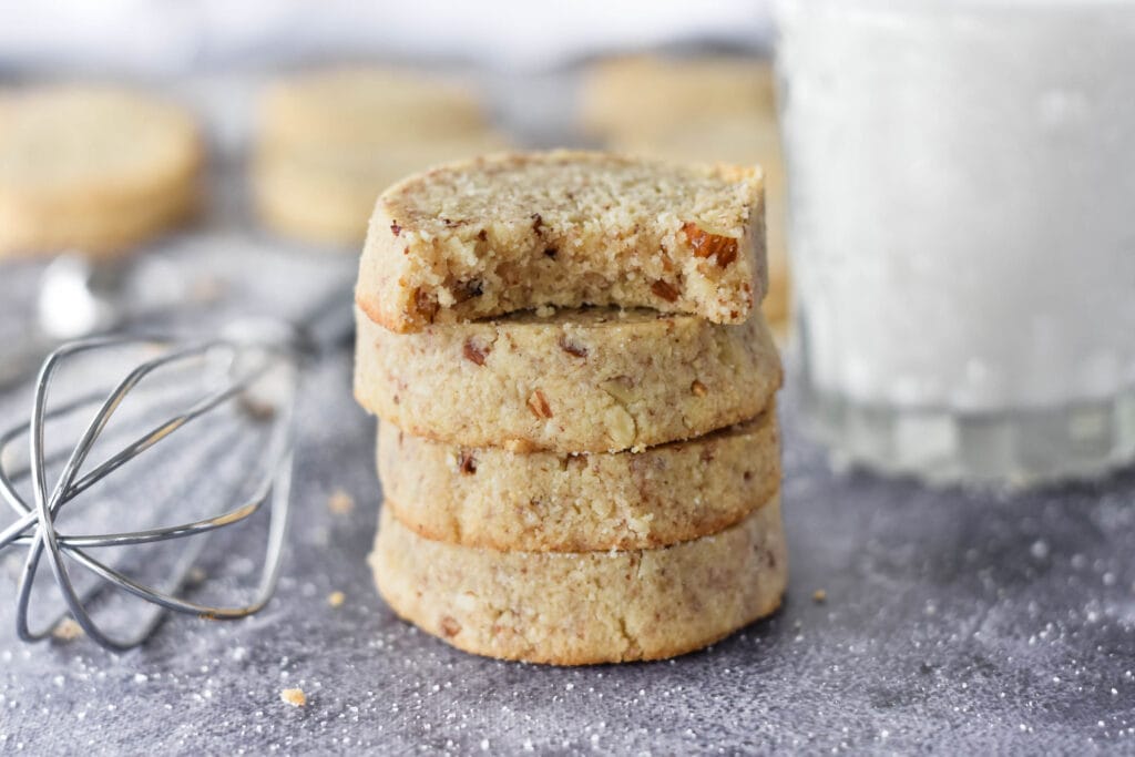 Stack of 4 keto pecan shortbread cookies, one with a bite out of it.