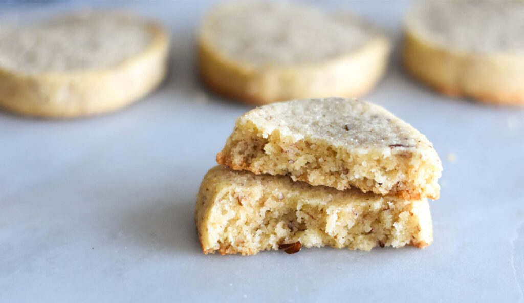 Keto pecan sandies cookie broken in half.