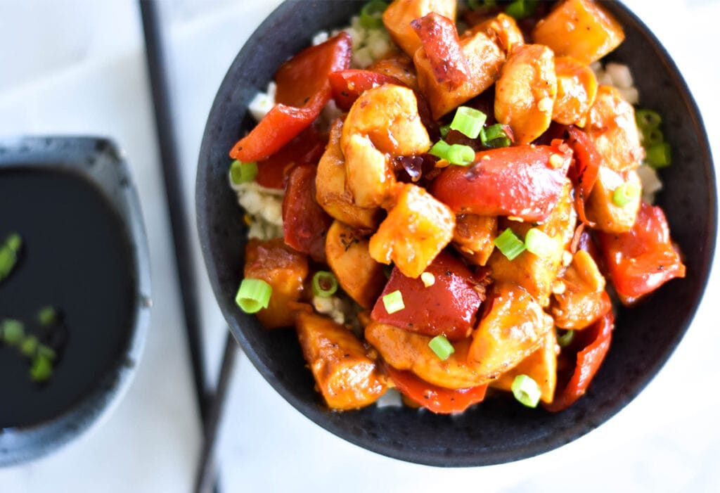 Top down view of whole30 pineapple chicken topped with green onions.