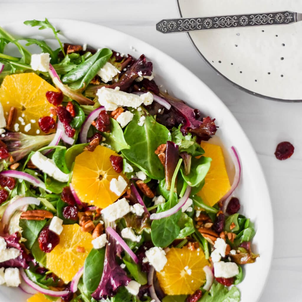 Brightly colored cherry citrus salad on serving plate.