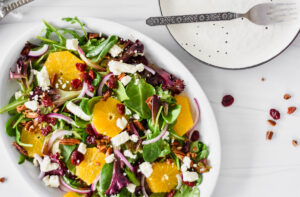 Brightly colored cherry citrus salad on serving plate.