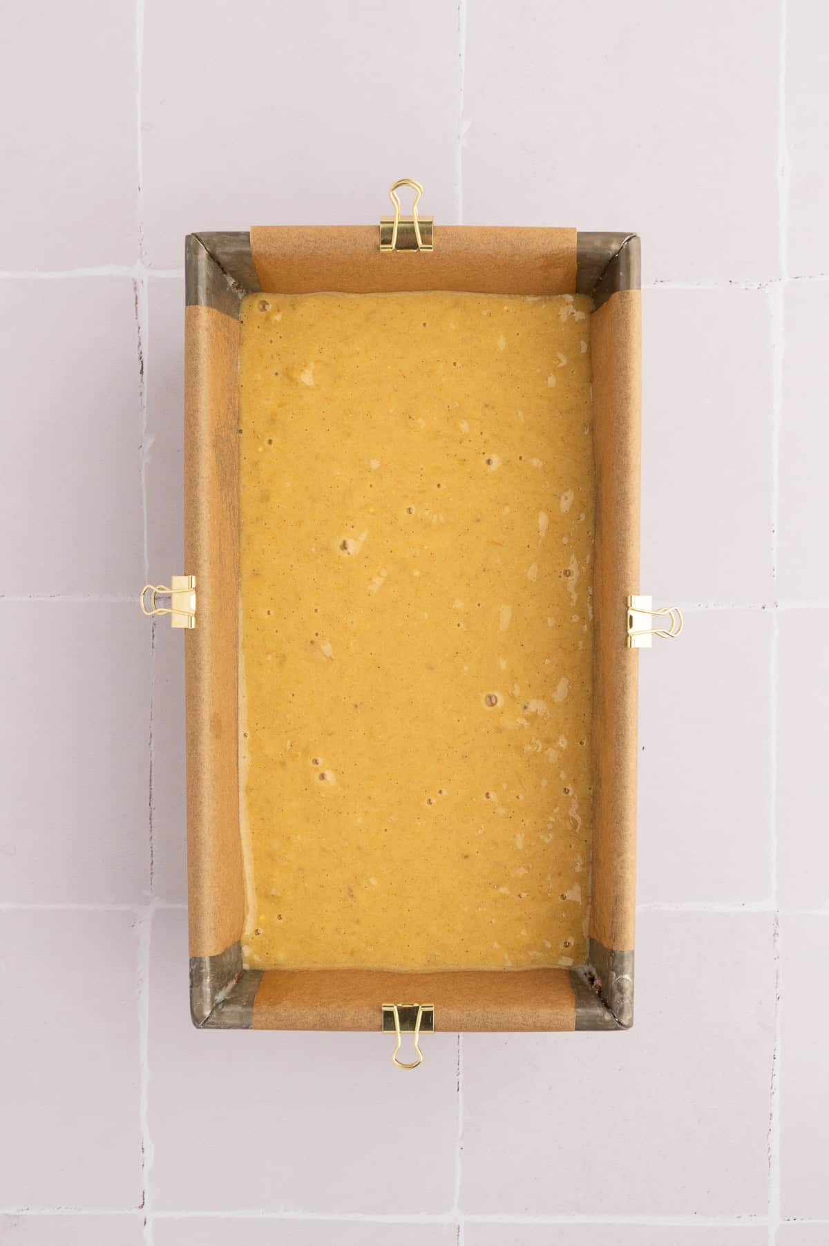Chickpea flour banana bread batter in a bread-an lined with parchment paper.
