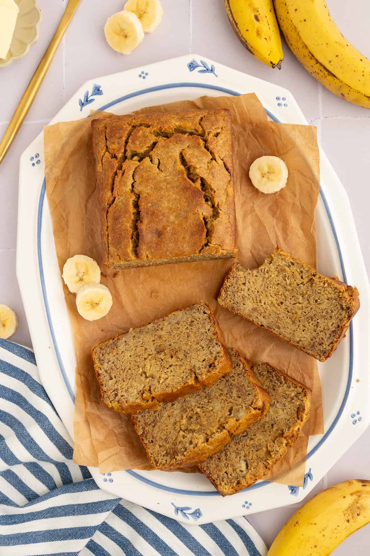 Sliced chickpea flour banana bread on a white platter with blue details.