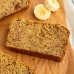 Slice of chickpea flour banana bread next to banana slices.