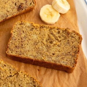 Slice of chickpea flour banana bread next to banana slices.