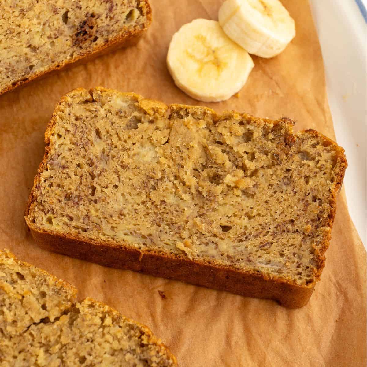 Slice of chickpea flour banana bread next to banana slices.