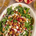 Pomegranate feta salad with maple walnuts on a platter.
