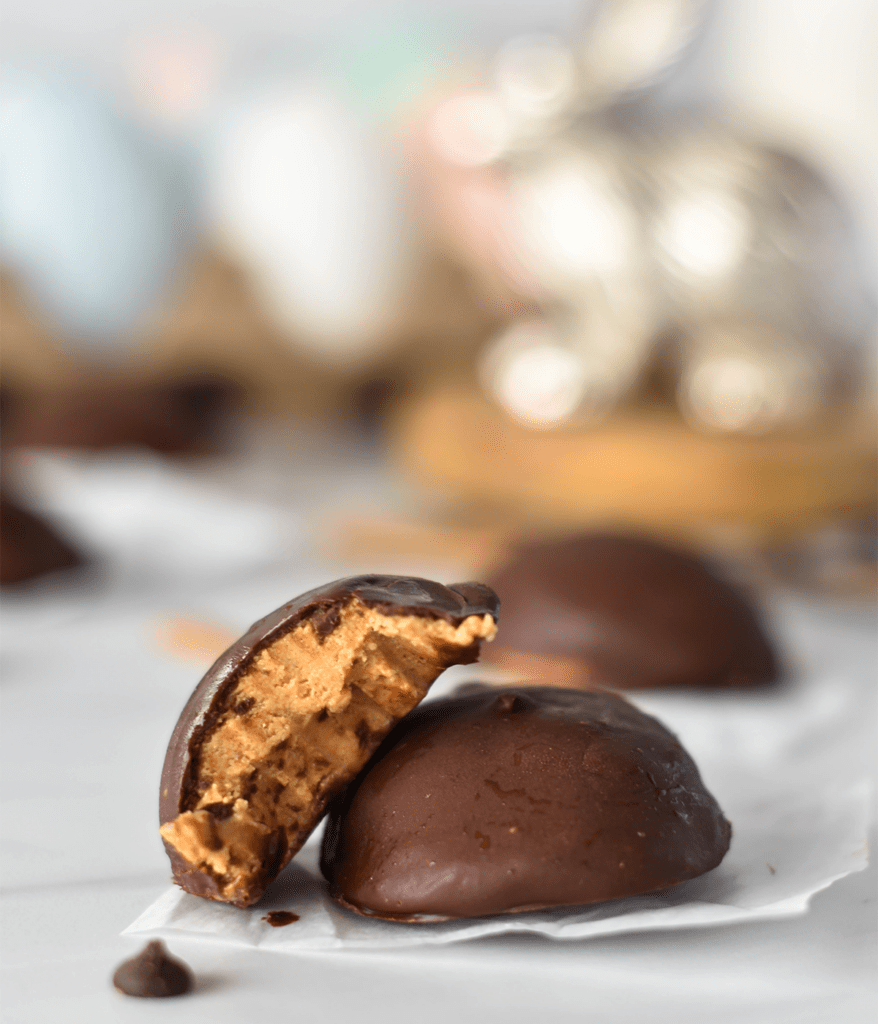 Two healthy Reese's Peanut Butter and Chocolate Eggs, one with a bite out of it.