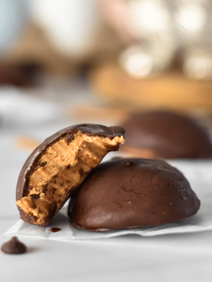 Two healthy peanut butter eggs, once with a bite out of it.