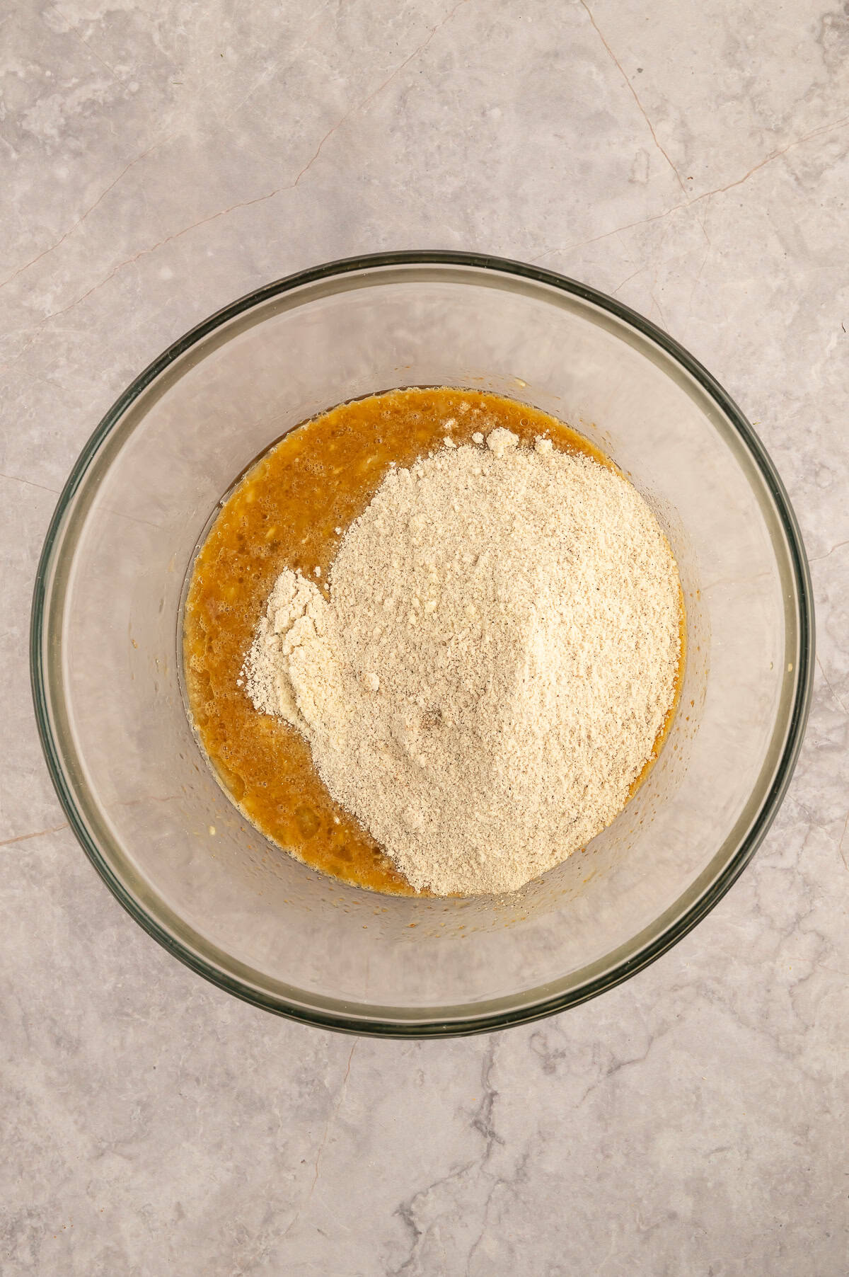 Wet ingredients and dry ingredients being combined in mixing bowl.