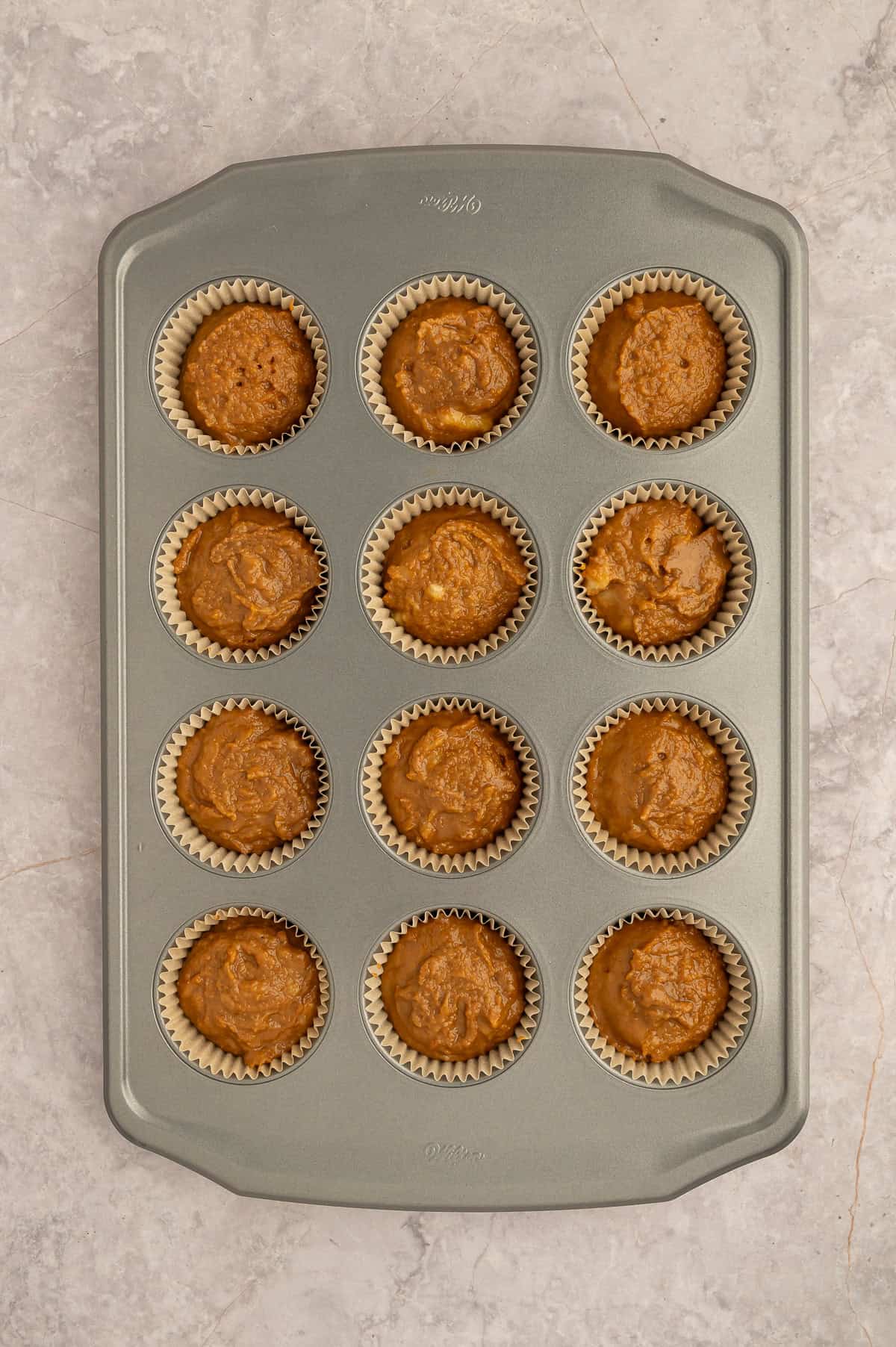 Batter for paleo banana espresso muffins inside a muffin tin.