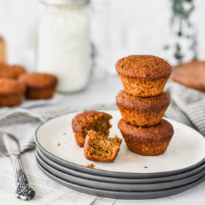 Stack of three paleo espresso banana muffins on a plate with one broken open.