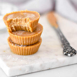 Stack of 3 dairy-free peanut butter fudge cups one with a bite out of it.