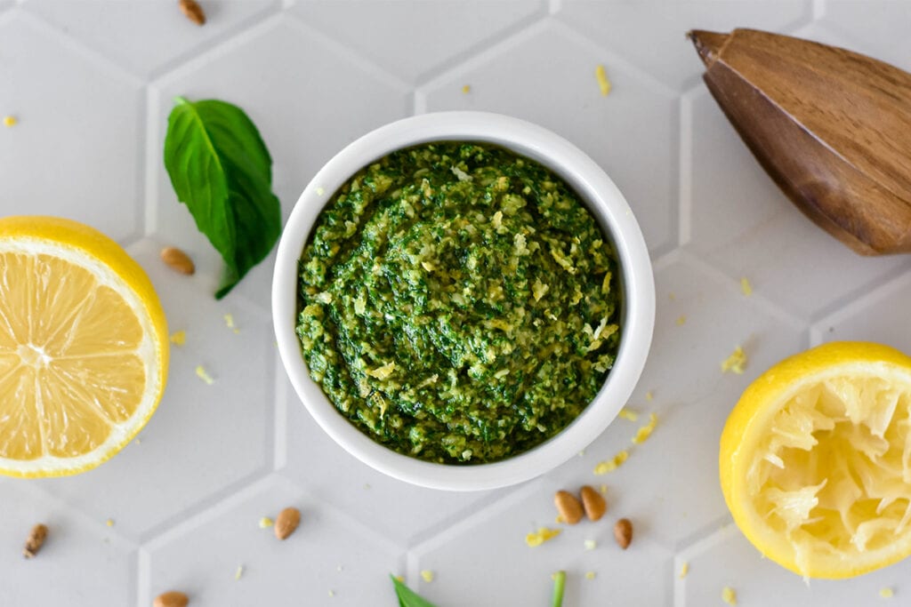 White dish filled with bright green lemon basil pesto.