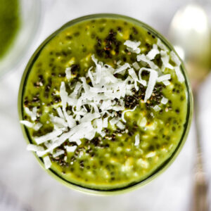 Top down view of bright green mactha overnight oats topped with coconut and chia seeds.