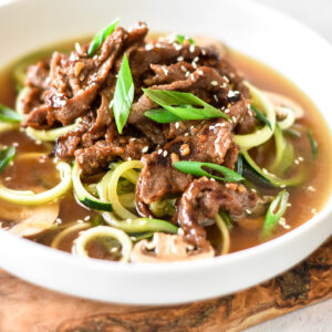 Bowl of bone broth with zucchini noodles and paleo bulgogi.