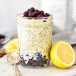 Mason jar filled with lemon overnight oats with blueberries layered in.