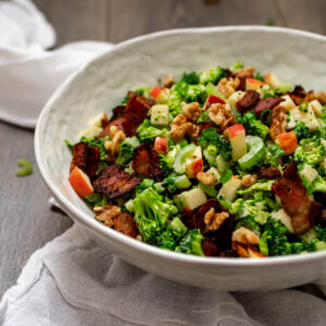 Bowl full of Paleo Broccoli Salad with bacon, apple and walnuts.