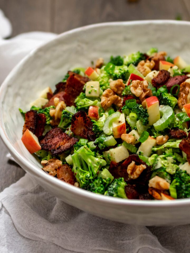 Bowl full of Paleo Broccoli Salad with bacon, apple and walnuts.