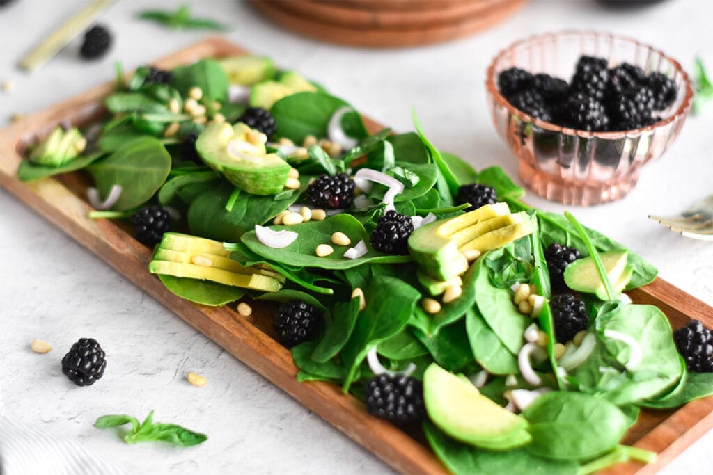 Brightly colored paleo blackberry avocado salad with shallot and blackberry vinaigrette.