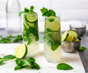 Two keto mojitos garnished with lime and mint.