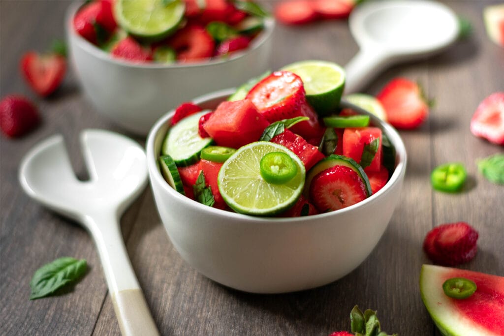 Two bowls full of vegan, paleo watermelon salad with lime, jalapeño, cucumber and strawberry.