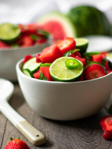 Two bowls full of vegan, paleo watermelon salad with lime, jalapeño, cucumber and strawberry.